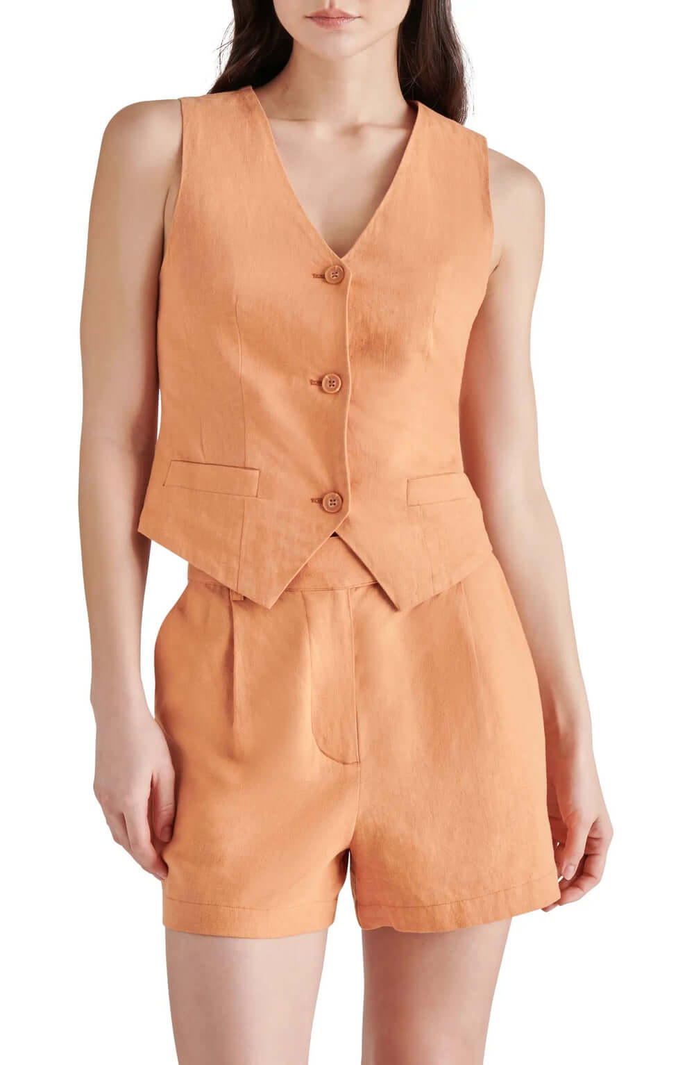 Woman wearing a stylish orange linen vest and shorts outfit, perfect for summer fashion.