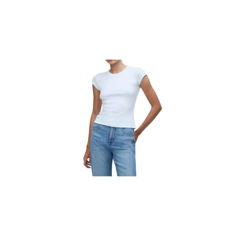Woman wearing a fitted white t-shirt paired with classic blue jeans, showcasing a casual and stylish outfit.
