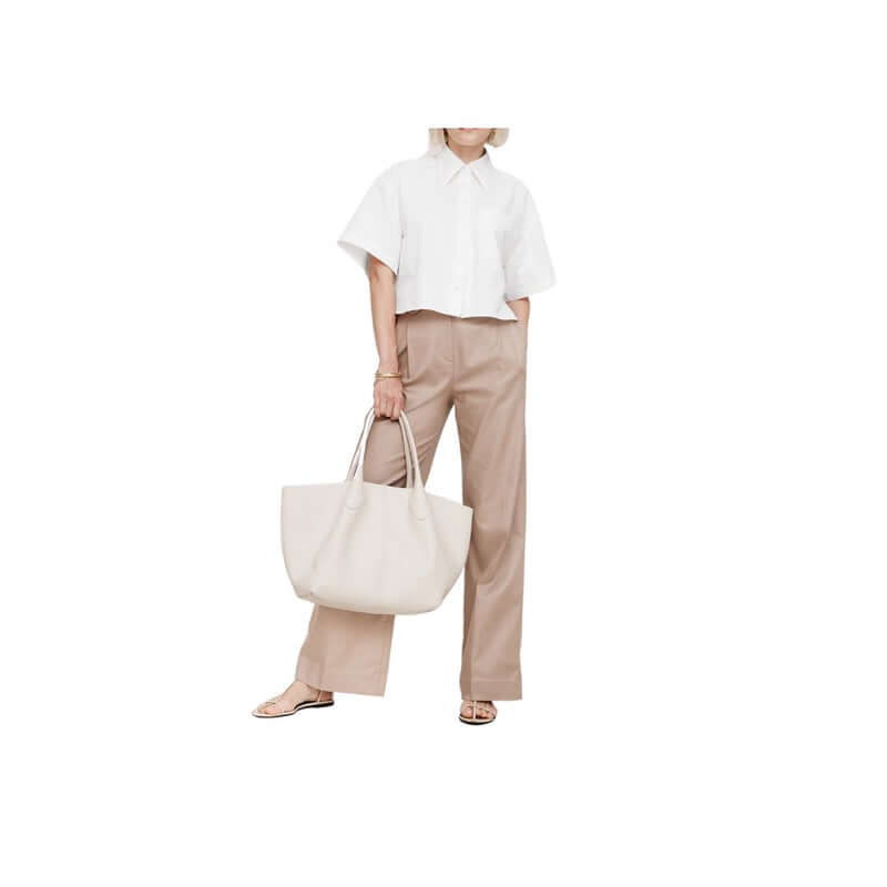 Casual outfit featuring a white cropped shirt and beige wide-leg pants, accessorized with a large tote bag.