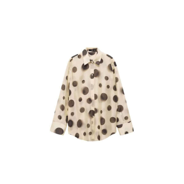 Cream button-up shirt with large black polka dots, stylish and trendy fashion staple.