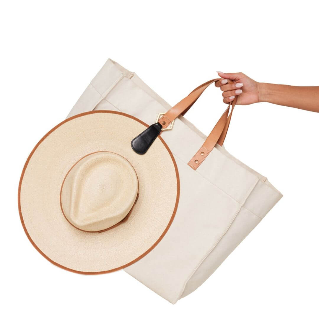 The Drop TOPTOTE hat clip made in faux leather with gold hardware attaches to your bag strap and carries your hat