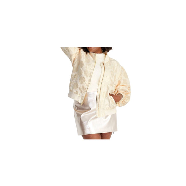 Model wearing a stylish cream bomber jacket over a trendy satin mini skirt.