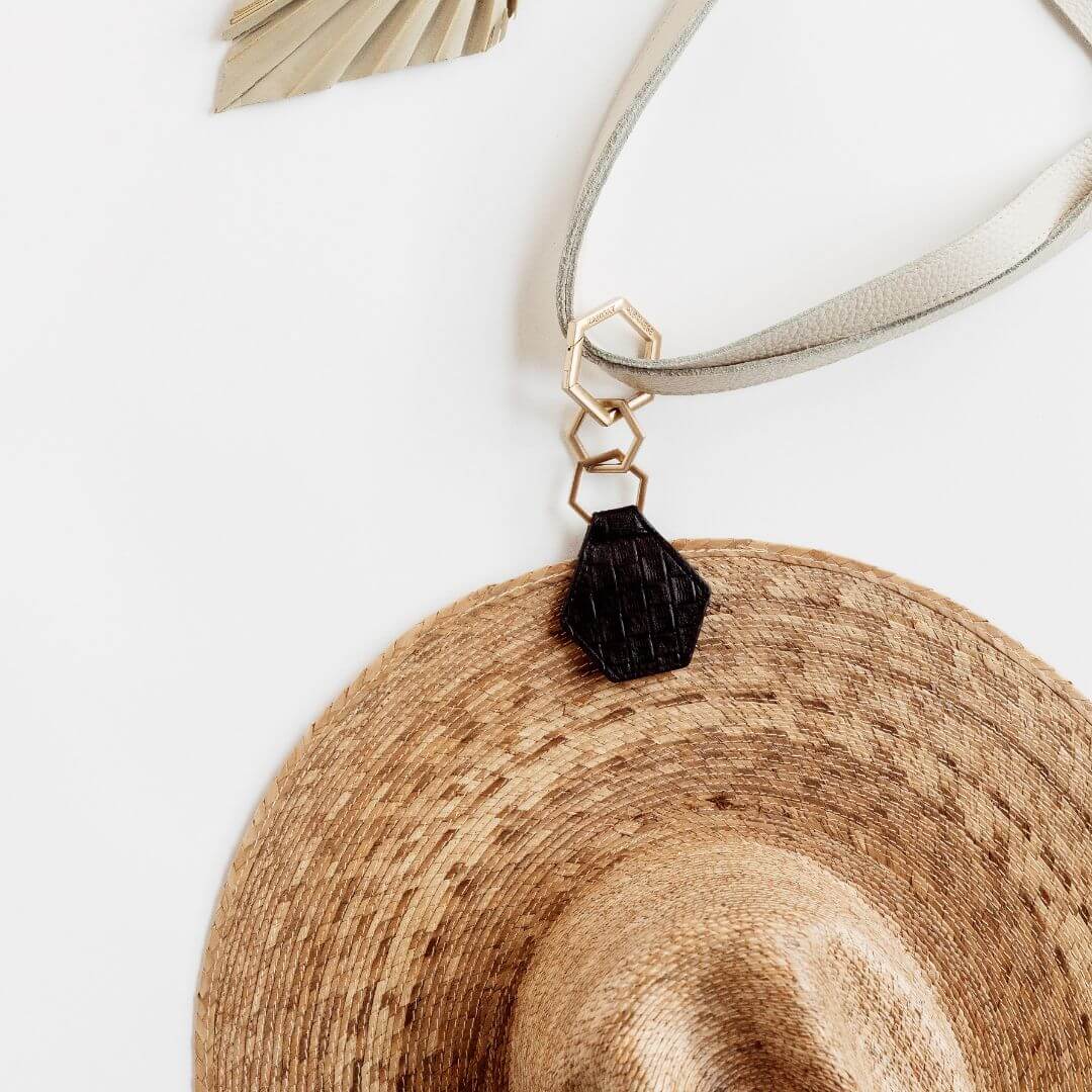 Hex TOPTOTE by Lindsay Albanese magnetic hat clip with gold hardware and genuine leather attached to a straw hat