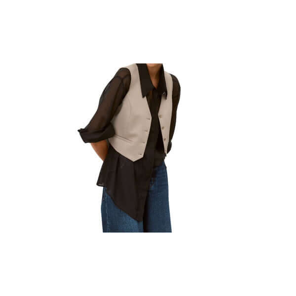 Stylish woman wearing a beige vest over a black shirt, complemented by blue jeans.