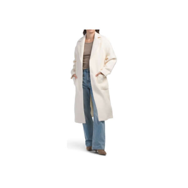 Woman wearing a cozy white long coat with jeans, showcasing a casual and stylish outfit.