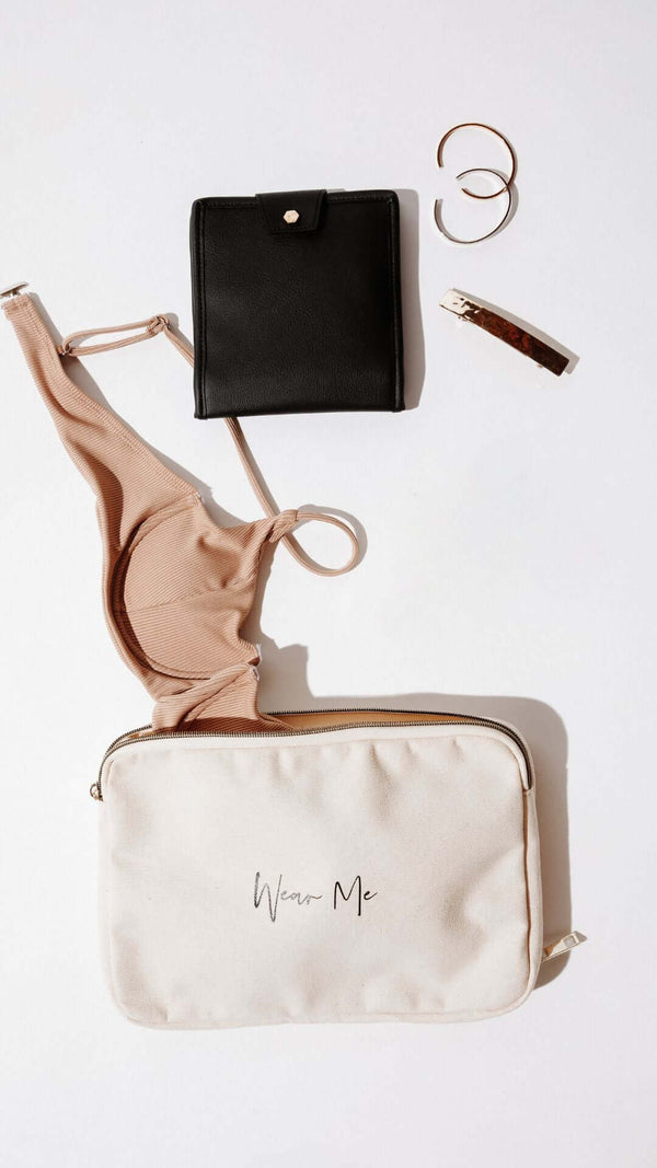 Fashion items layout: beige bikini, black wallet, and cream makeup bag with 'Wear Me' text.