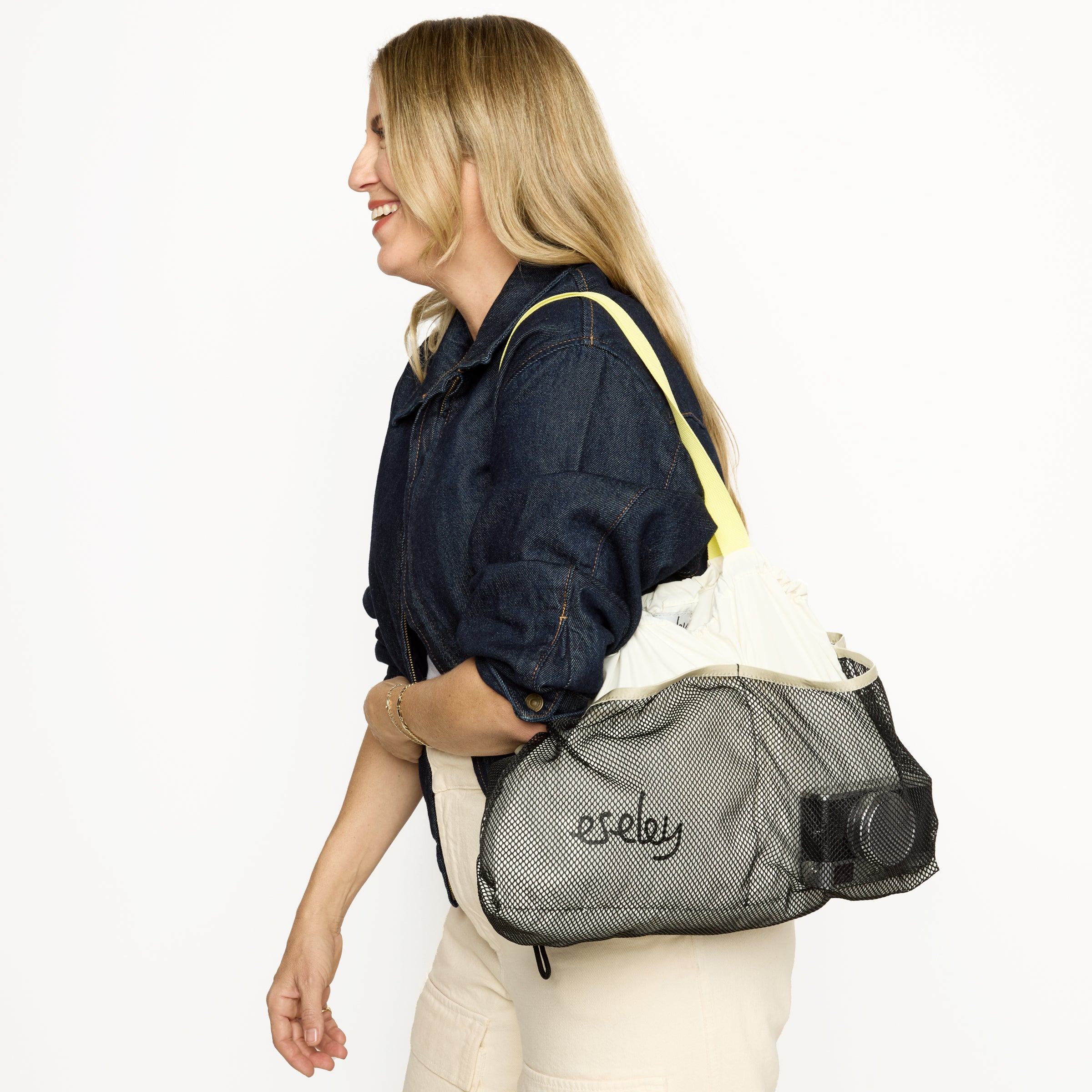 Woman carrying a mesh bag with 'eseley' branding on a white background