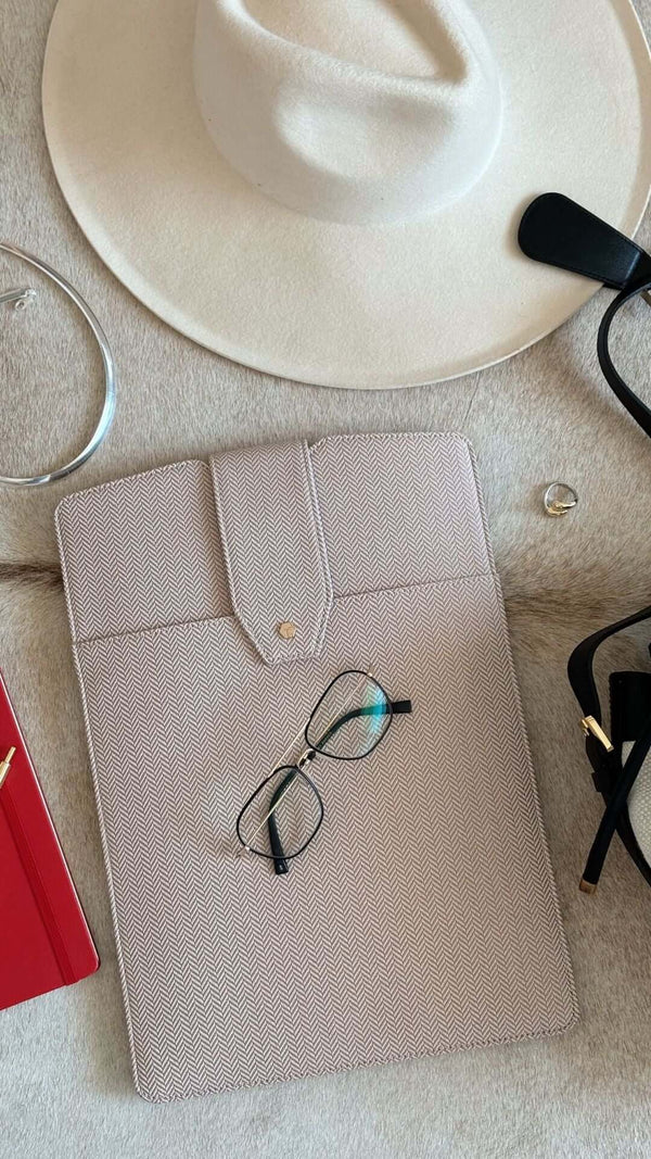 Fashion accessories including a hat, stylish glasses, and a chic organizer on a soft surface.
