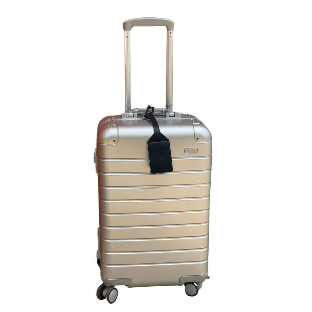 TOPTOTE luggage tag hat clip attached to a silver suitcase.