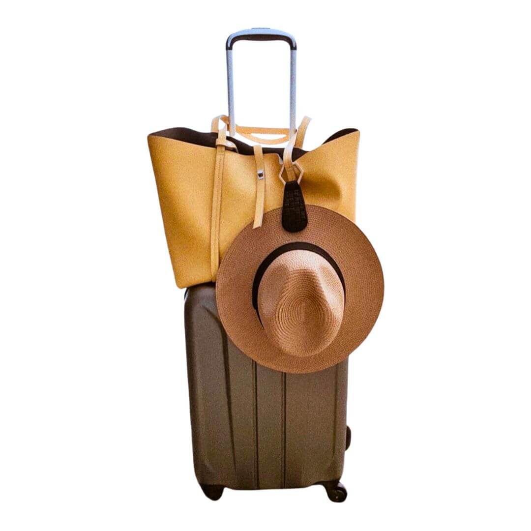 The Drop TOPTOTE magnetic Hat Clip in black with gold clasp, designed for securely carrying hats hands-free while traveling.